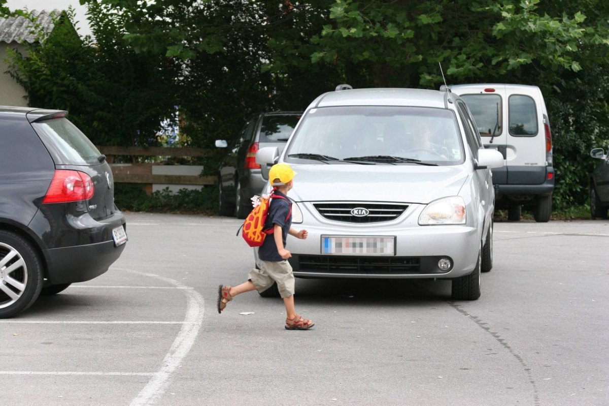 Kleiner Junge rennt über die Straße vor ein Auto