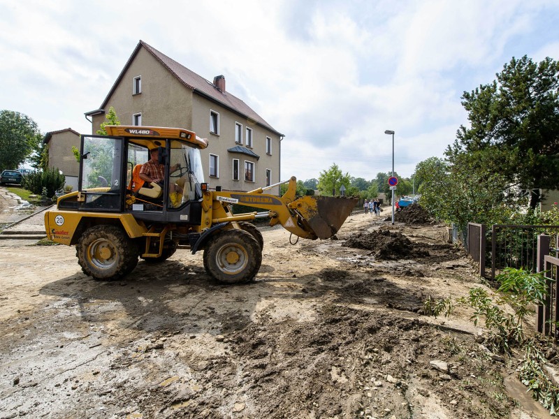 Eine Schlammlawine hat sich durch Tiefurt, einen Ortsteil von Weimar, gewälzt. Das Erdreich hatte sich am Freitagabend (17.08.2018) gelöst, als ein schweres Unwetter über die Region zog. Ein kurzer, aber heftiger Starkregen spülte das Material von einem Feld durch mehrere Grundstücke. Am Tag danach machten sich die Anwohner an die Aufräumarbeiten. Das Unwetter hatte auch an anderen Stellen in Weimar für Schäden gesorgt. So stürzte in der Innenstadt in einer Wohnung durch Wassereinbruch eine Zimmerdecke ein; von Bäumen brachen viele Äste ab, in einen davon fuhr ein Linienbus. Der Park an der Ilm sowie die Parks in Tiefurt und Belvedere wurden gesperrt.