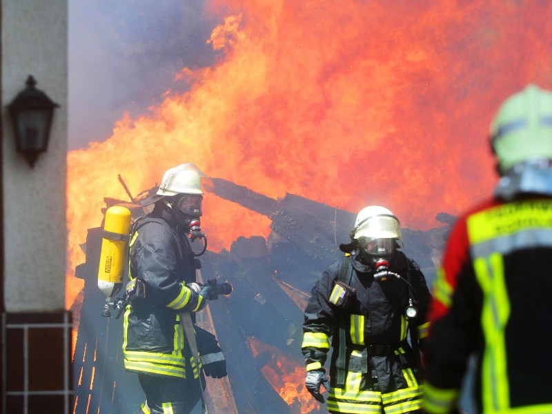 Feuerwehrleute am 16.06.2017 im Einsatz an einem in Flammen stehenden Anwesen im südthüringischen Effelder (Kreis Sonneberg). Die Anwohner hätten das Haus rechtzeitig verlassen können, ein Feuerwehrmann hätte beim Löschen jedoch eine Rauchvergiftung erlitten, teilte die Polizei am Freitag mit. Die Gebäude brannten bis auf die Grundmauern nieder. Im Einsatz waren Feuerwehren aus Thüringen und dem benachbarten Bayern. Foto: Stefan Thomas/dpa