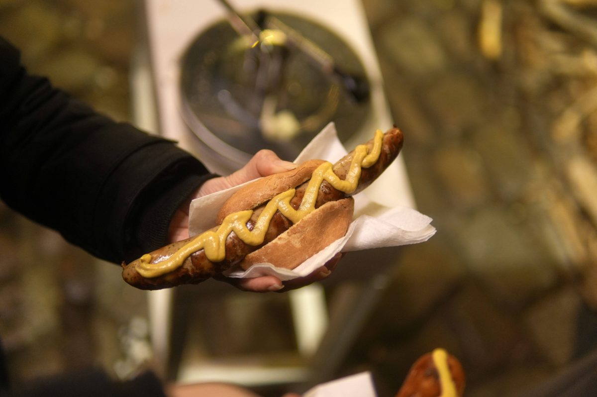 Ein Mann hält ein Brötchen mit einer Bratwurst in der Hand (Symbolbild Thüringen)