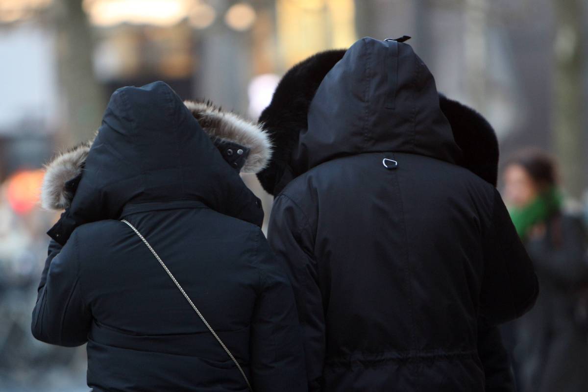 Personen versuchen sich vor der Eiskälte und den Sturmböen zu schützen in der Innenstadt Frankfurt